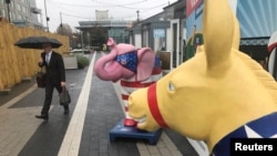 FILE - A commuter walks past a symbolic Republican elephant and Democratic donkey at a metro station in Reston, Virginia, Nov. 5, 2018, one day before U.S. congressional midterm elections.