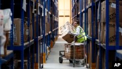 Lovespace warehouse worker Pawel Mazur unloads boxes from a trolley to place them into their allocated zones at the warehouse in Dunstable, England, Jan. 14, 2019. 