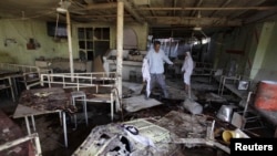 People inspect damaged cafe following suicide bombing, Balad, 80 kilometers north of Baghdad, Aug. 13, 2013.
