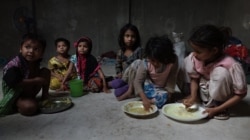 Some Rohingya refugee children taking their meals inside a refugee camp in West Bengal. (Shaikh Azizur Rahman/VOA)