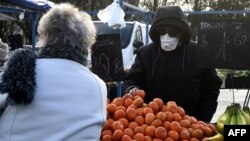 A man wearing a protective mask shops in the market of Crepy-in-Valois on March 1, 2020, before its evacuation following the outbreak of COVID-19. 
