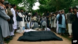 Victims' bodies are placed on the ground after heavy flooding in Baghlan province in northern Afghanistan on May 11, 2024.