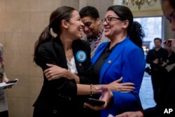 FILE - Rep. Alexandria Ocasio-Cortez, D-N.Y., left, and Rep. Rashida Tlaib, D-Mich., wait for other freshman members of Congress to deliver a letter calling for an end to the government shutdown, which was delivered to the office of the Senate majority leader on Capitol Hill in Washington, Jan. 16, 2019.
