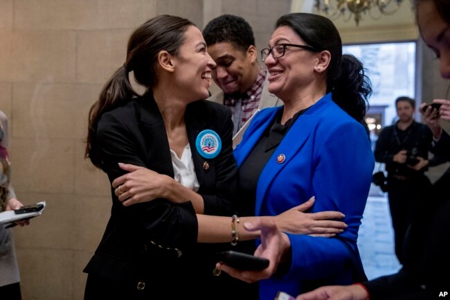 FILE - Rep. Alexandria Ocasio-Cortez, D-N.Y., left, and Rep. Rashida Tlaib, D-Mich., wait for other freshman members of Congress to deliver a letter calling for an end to the government shutdown.