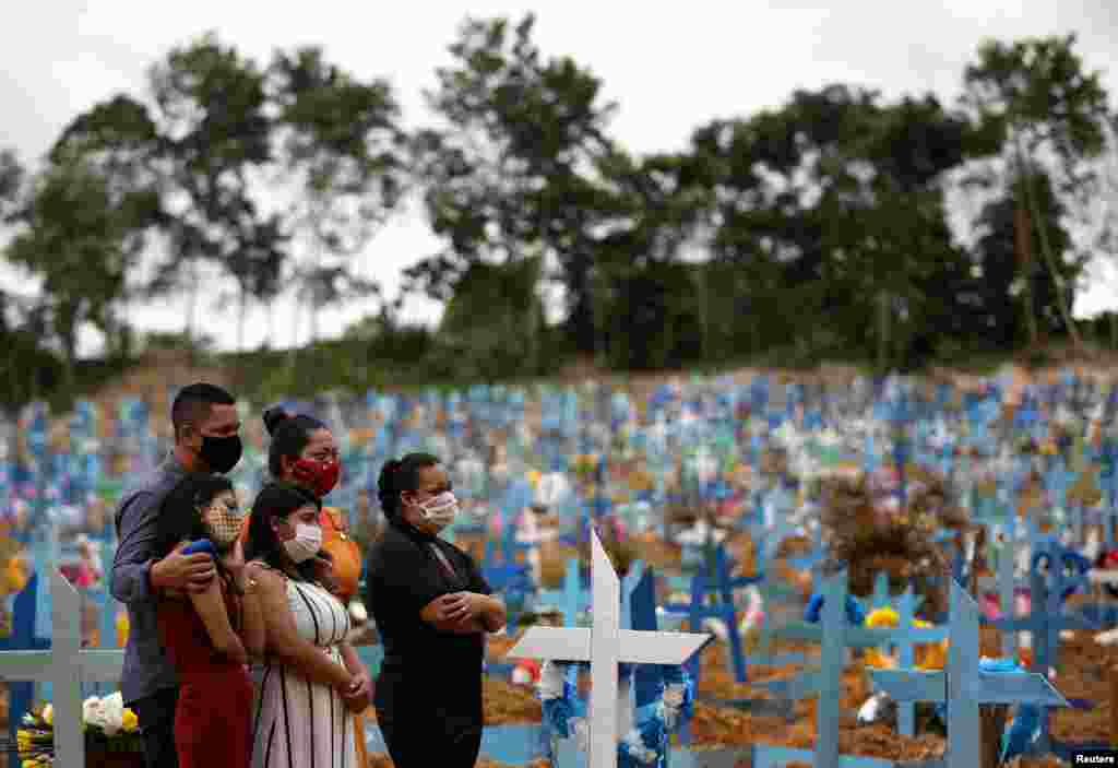 Family members are seen during a mass burial of people who died from coronavirus complications, at the Parque Taruma cemetery in Manaus, Brazil.