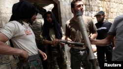 Free Syrian Army fighters display what they said were shells used by forces loyal to Syria's President Bashar al-Assad during clashes with them in Aleppo's Karm al-Jabal district, June 2, 2013. 
