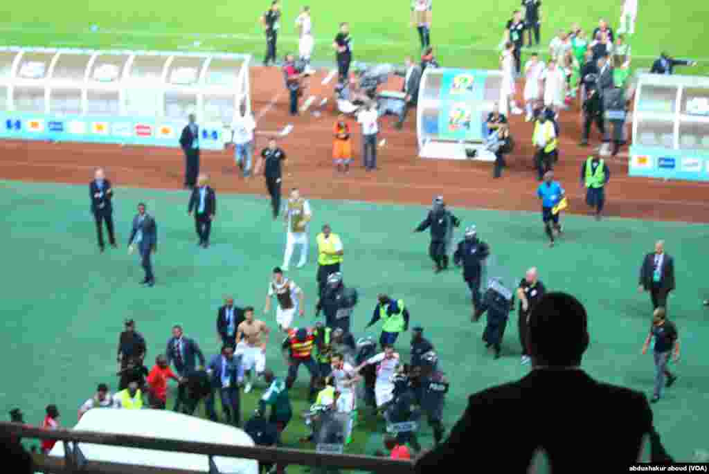 Police officers separate tournament officials from Tunisian players who wanted to attack the referee for his calls during their game against Equatorial Guinea, January 31, 2015.