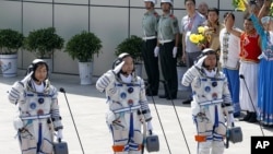 Ba phi hành gia Trung Quốc (từ trái sang phải) Liu Yang, Jing Haipeng và Liu Wang chào trước khi đi vào phi thuyền Thần Châu 9, ngày 16 tháng 6, 2012