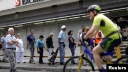 Venezuelan citizens line up to buy food at a store after a strike called to protest against Venezuelan President Nicolas Maduro's government in Caracas, Venezuela, July 29, 2017.