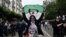 An Algerian woman waves a national flag as she takes part in an anti-government demonstration in the capital Algiers on March 14, 2020.