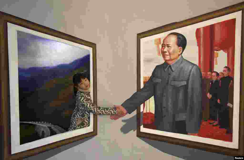 Seorang anak perempuan berpose dengan lukisan 3D (3 dimensi) mendiang Mao Zedong pada sebuah pameran seni di kota Binzhou, provinsi Shandong, China.