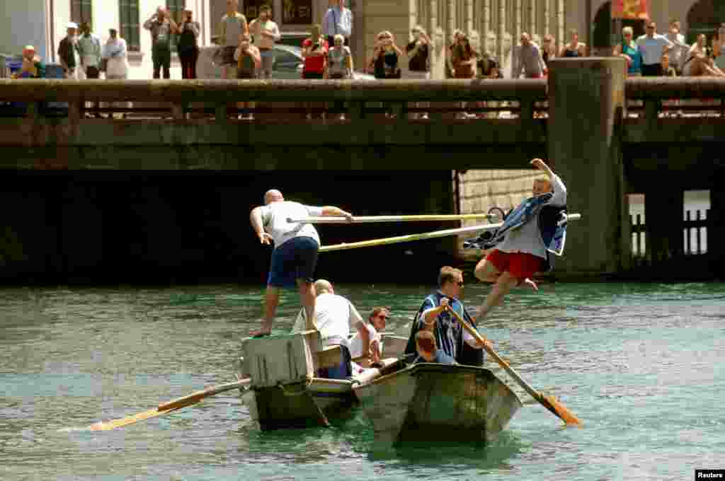 A participant standing on the back of a boat uses a lance to push a competitor from another boat during the traditional Schifferstechen event, celebrated by the boatmen&#39;s guild similar to medieval jousting, on the river Limmat in Zurich, Switzerland, July 7, 2018.