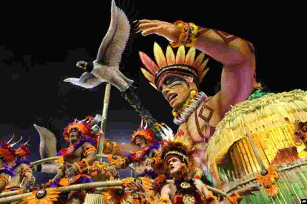 Carnival dancers perform on a float during a parade by the Perola Negra samba school in Sao Paulo, Brazil, early Sunday Feb. 19, 2012.