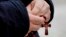 FILE - A man holds rosary beads as he prays for Pope Francis in front of the Agostino Gemelli Polyclinic, where the Pontiff has been hospitalized since Feb. 14, in Rome, Feb. 26, 2025.