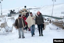 Wesley Clark Jr., center, talks with opponents of the Dakota Access oil pipeline and with local law enforcement on Backwater Bridge near Cannon Ball, N.D., Dec. 2, 2016.