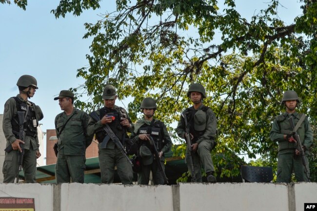 Soldiers are seen at a military headquarter as opposition supporters (not pictured) give out copies of amnesty measures to anyone in the military who disavows President Nicolas Maduro, in Caracas, Venezuela, Jan. 27, 2019.