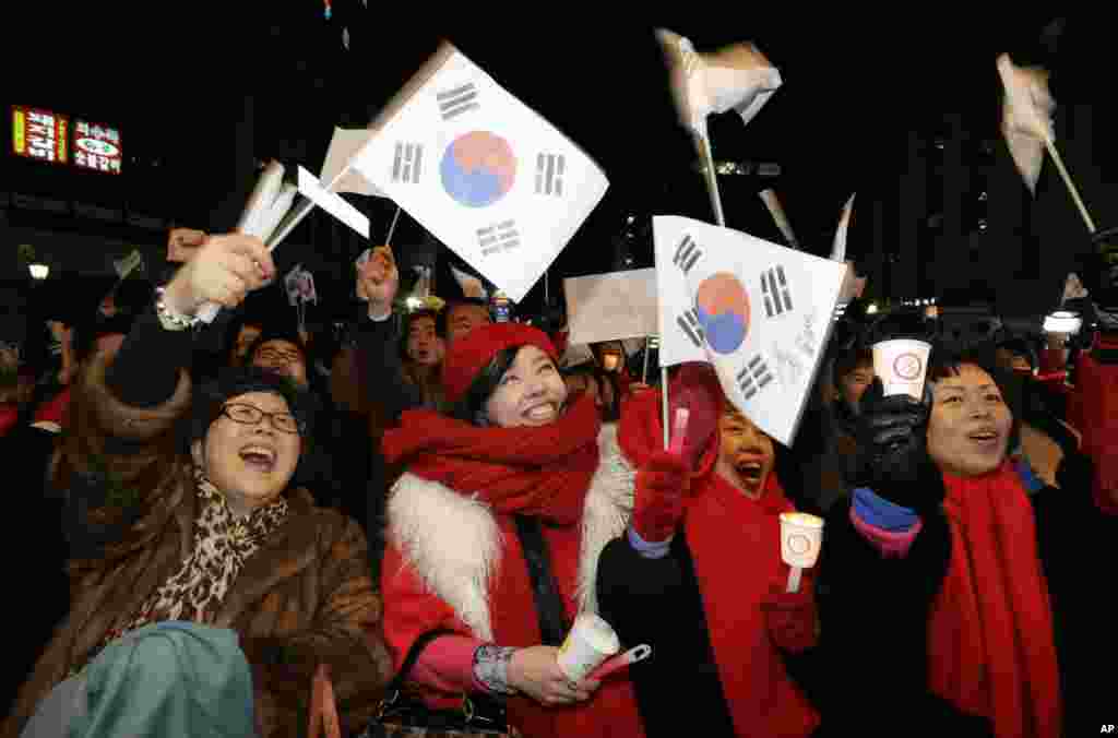 Supporters of Park Geun-hye cheer near her Saenuri Party's head office in Seoul, December 19, 2012.