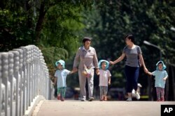 세계어린이날인 지난해 6월 9일 두 여성과 아이들이 중국 베이징의 다리를 걷고 있다.