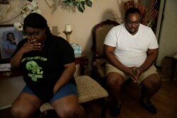 FILE - Cousins Latasha Taylor, left, and Desmond Tolbert sit during an interview on April 18, 2020 in Dawson, Ga. Both have been affected by the COVID-19 deaths of Tolbert's parents.