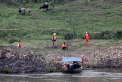 FILE - A Chinese team of geologists surveys the Mekong River banks, at the Laos side, at the border between Laos and Thailand, April 23, 2017.