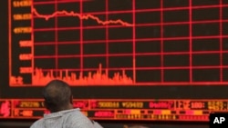 FILE - An investor watches as the Shanghai Composite Index falls at a brokerage in Beijing, China, May 6, 2019. The coronavirus outbreak has caused an economic ripple effect throughout Asia.