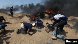 8일 가자지구 이스라엘 접경에서 팔레스타인 시위대가 이스라엘 군의 총격을 피해 몸을 숨기고 있다.
