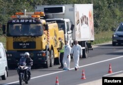 A truck in which up to 50 migrants were found dead, is prepared to be towed away on a motorway near Parndorf, Austria, Aug. 27, 2015.