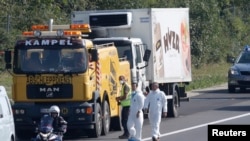 A truck in which up to 50 migrants were found dead, is prepared to be towed away on a motorway near Parndorf, Austria, Aug. 27, 2015. 