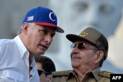 Le président cubain Miguel Diaz-Canel (à gauche) écoute l'ancien président Raul Castro lors du rassemblement du 1er mai à la place de la Révolution à La Havane le 1er mai 2018.