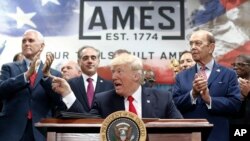 President Donald Trump, joined by Vice President Mike Pence, (from left) Secretary of Veterans Affairs David Shulkin, and Wilbur Ross United States Secretary of Commerce, signs an Executive Order on the Establishment of Office of Trade and Manufacturing.