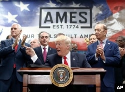 President Donald Trump, joined by Vice President Mike Pence (from left), Secretary of Veterans Affairs David Shulkin, and Wilbur Ross United States Secretary of Commerce, signs an Executive Order on the Establishment of Office of Trade and Manufacturing Policy at The AMES Companies, Inc., in Harrisburg, Pa., April, 29, 2017.