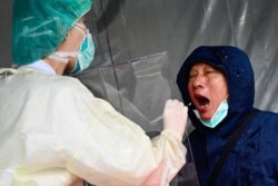 A medical staff collects a sample for testing during a drill organized by the New Taipei City government to prevent the spread of the COVID-19 coronavirus, in Xindian district, Taiwan, March 14, 2020.