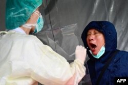 A medical staff collects a sample for testing during a drill organized by the New Taipei City government to prevent the spread of the COVID-19 coronavirus, in Xindian district, Taiwan, March 14, 2020.