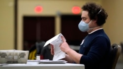 PENNSYLVANIA – A worker at the convention center in Lancaster, PA, opens a mail-in ballots to prepare them for counting, on November 4, 2020.