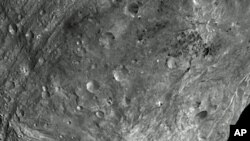 In this image, obtained by Dawn's framing camera, a peak at Vesta's south pole is seen at the lower right. The grooves in the equatorial region are about 10 kilometers wide. The image was taken on July 24, 2011, from a distance of about 5,200 kilometers