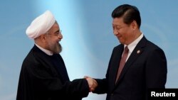 Iran's President Hassan Rouhani, left, shakes hands with his Chinese counterpart Xi Jinping at the fourth Conference on Interaction and Confidence Building Measures in Asia summit in Shanghai, May 21, 2014. The two will meet again on the sidelines of the Eurasian Shanghai Cooperation Organization meeting in June. 