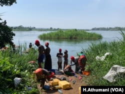 Women bathe and do laundry at the shores of Victoria Nile River, Kayunga district, Uganda.