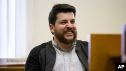 A leading associate of Russian opposition leader Alexei Navalny, Leonid Volkov, smiles in a courtroom during a hearing in Moscow, March 31, 2017.