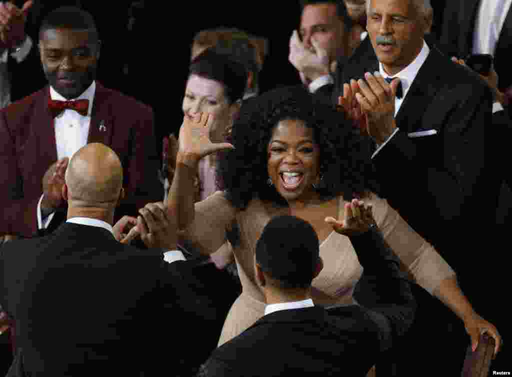 Ophra Winfrey (C) félicite John Legend (en bas D) et Commun (en bas G),&nbsp;pendant que&nbsp;l&#39;acteur David Oyelowo (haut à gauche) regarde, après que &quot;Glory&quot; du film &quot;Selma&quot; a remporté l&#39;Oscar de la meilleure chanson originale lors de la 87e Oscars à Hollywood, en Californie&nbsp;