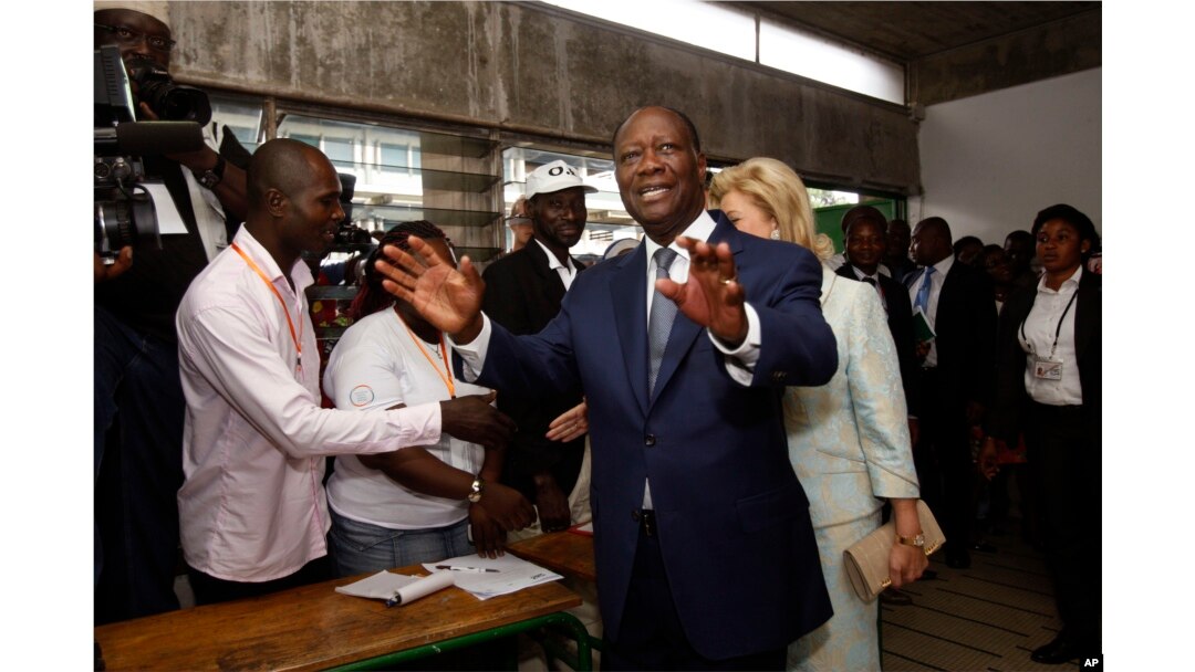 Ivory Coast’s President Alassane Ouattara arrives inside a polling station to cast his ballot during elections in Abidjan, Oct. 25, 2015.