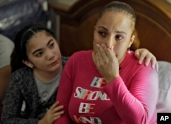 In this Jan. 23, 2018 photo, Leslie Rivera is comforted by her daughter Yandeliz during an interview in their hotel room at the Rodeway Inn in Tampa, Florida, where they're living after Hurricane Maria destroyed their home in Puerto Rico.