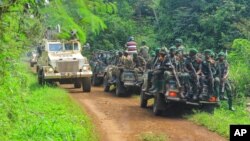 FILE - Congolese soldiers and U.N. forces patrol the area of an attack by suspected Allied Democratic Forces near Oicha, 30 kms from Beni, Democratic Republic of Congo, 7.23.2021