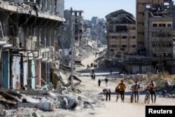 Palestinians make their way in a devastated neighborhood in Gaza City on Oct. 24, 2024.