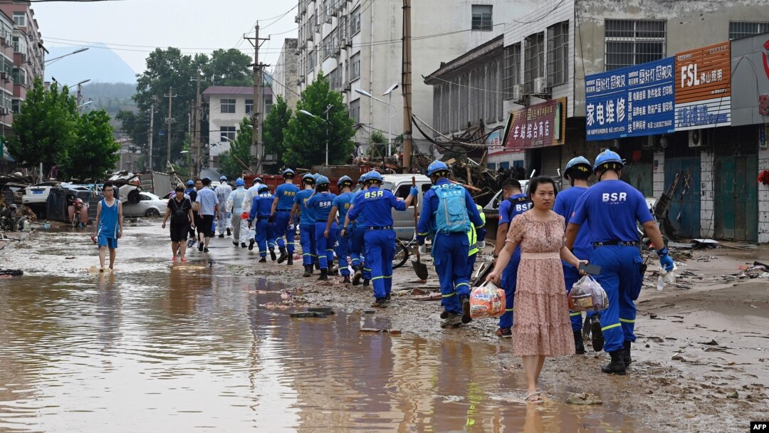 Petugas melakukan pembersihan di Gongyi, dekat Zhengzhou, provinsi Henan, China (22/7). 