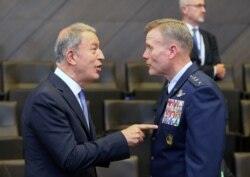 Turkey's Defense Minister Hulusi Akar, left, and Supreme Allied Commander Europe U.S. Air Force General Tod Wolters attend a NATO Defense Ministers meeting in Brussels, June 26, 2019.