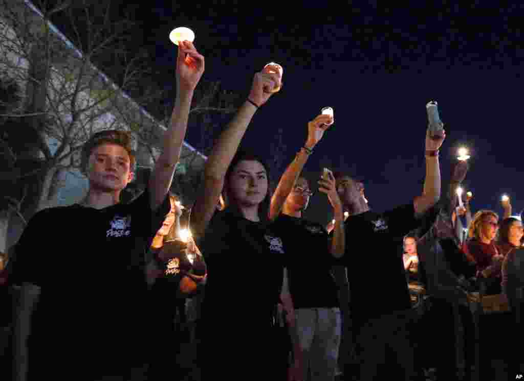 Attendees raise their candles at a candlelight vigil for the victims of the shooting at Marjory Stoneman Douglas High School, Feb. 15, 2018, in Parkland, Fla.