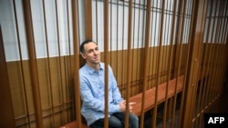 FILE - Laurent Vinatier sits inside a defendants' cage during a hearing in Moscow's Zamoskvoretsky district court on Oct.14, 2024.