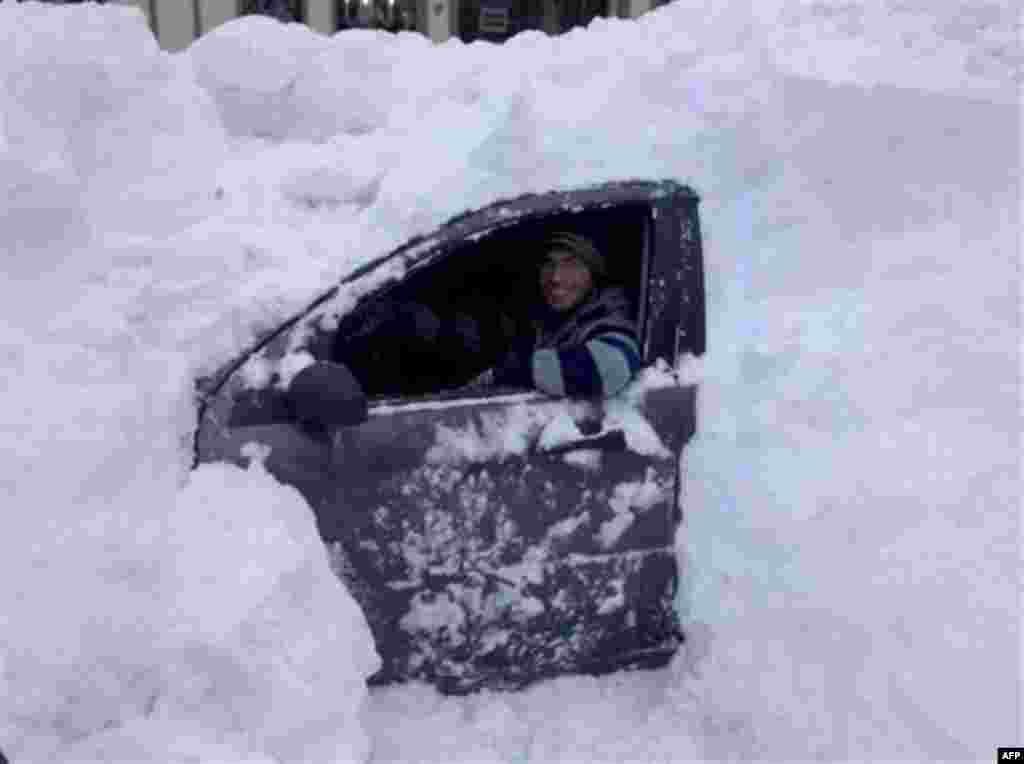 Dave Duncan sits in his Ford Focus, buried on the street Tuesday, Dec. 28, 2010 in Asbury Park, N.J. (AP Photo/Beth DeFalco)