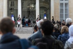 People line up to sign a condolence book for the late French President Jacques Chirac, Sept. 27, 2019, in the courtyard of the Elysee Palace in Paris.
