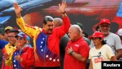 El jefe de Estado venezolano, Nicolás Maduro, conversa con el primer vicepresidente del partido de gobierno, Diosdado Cabello, durante un mitin político en Caracas, el 29 de febrero de 2024.